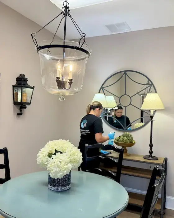 E3R team member cleaning a dining room with a glass table