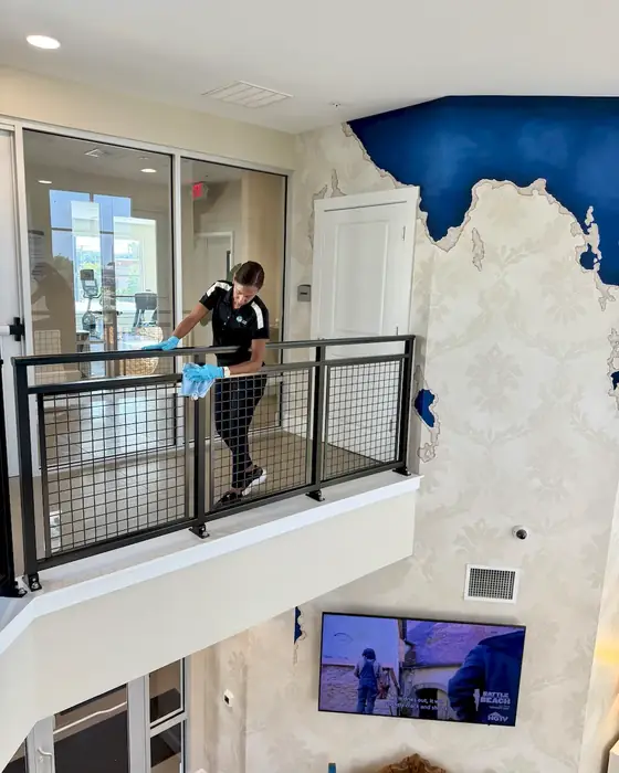 E3R team member cleaning a glass railing