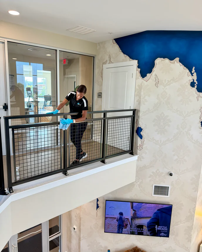 E3R team member cleaning a glass railing