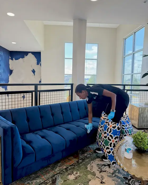 E3R team member cleaning a blue sofa