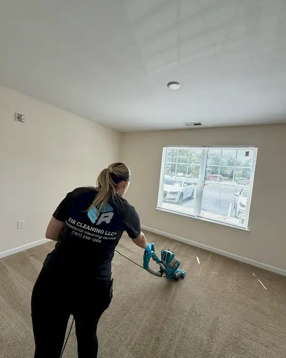 E3R team member cleaning the floor of an empty room