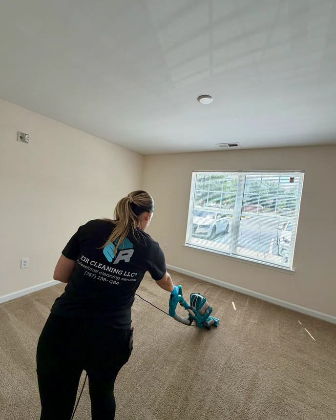 E3R team member cleaning the floor of an empty room